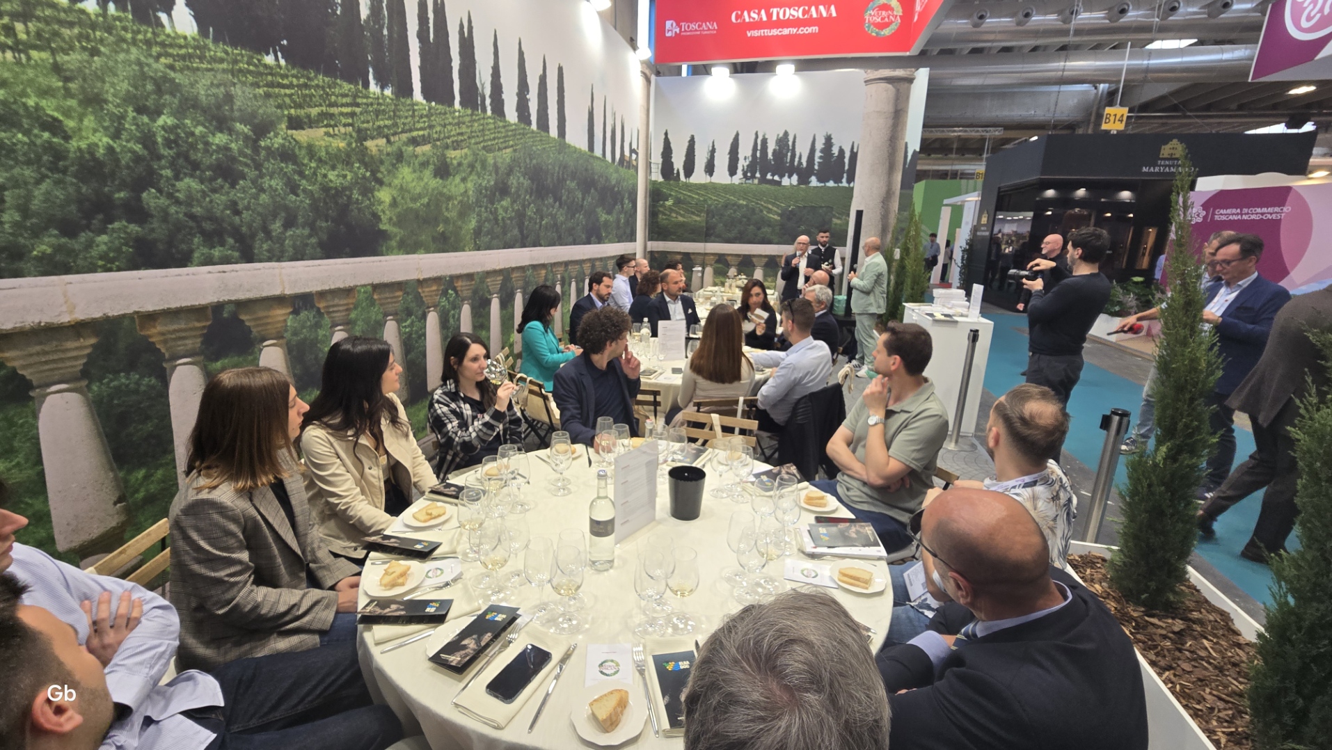 Immagine di persone sedute a tavoli tondi per degustazioine vini